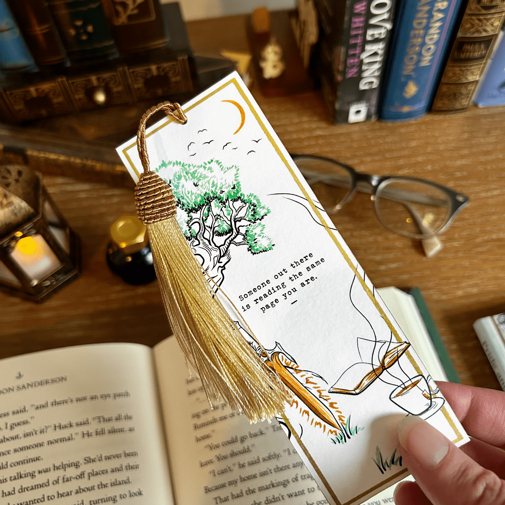 Fantasy Reading The Same Page Bookmark for readers viewed over a desk with books glasses, and a lantern.