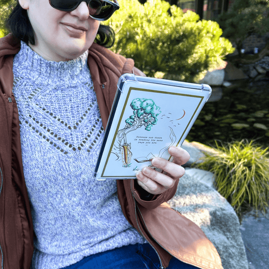 Fantasy Reading The Same Page Kindle Case Insert for readers. Woman holding Kindle in garden.