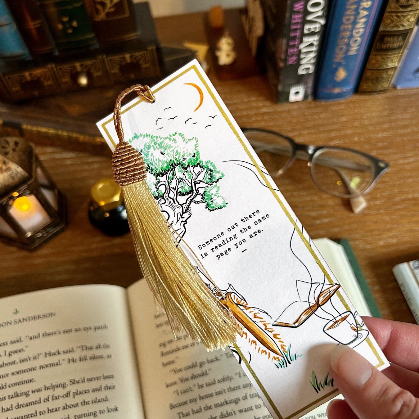 Fantasy bookmark featuring geekycleary's Reading The Same Page illustration viewed over a desk in our bookish store.