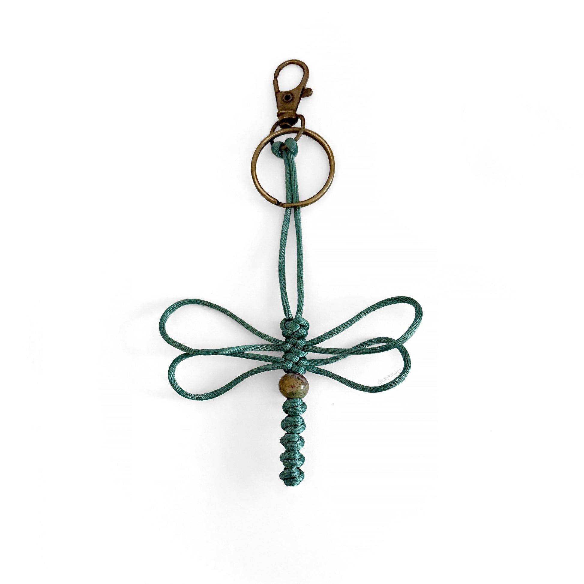 Teal-colored dragonfly keychain handwoven with silk cord and real agate bead. Durable brass colored clip and keyring.